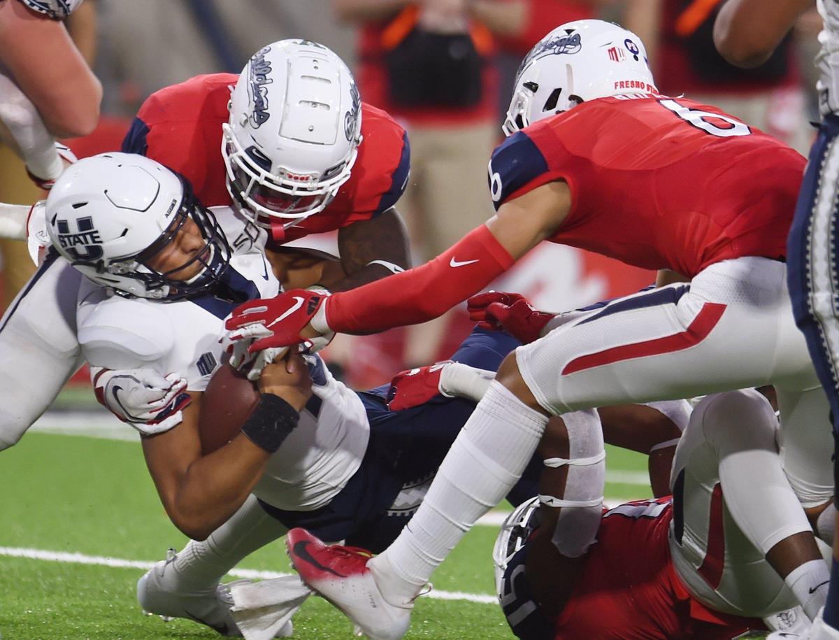 Fresno State’s Mykal Walker, background, Levelle Bailey, right, are in on the sack of Utah State’s quarterback Jordan Love, front right, Saturday, Nov 9, 2019 in Fresno. The Aggies won 37-35 on a field goal as time expried.