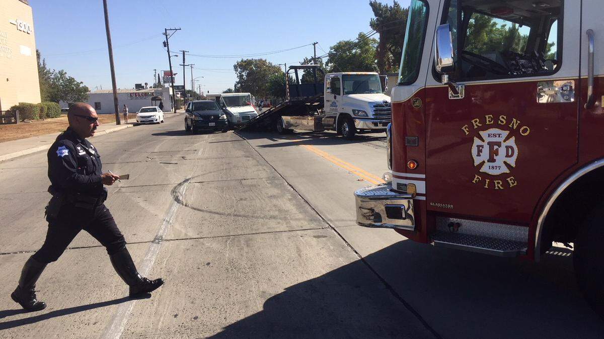 A Fresno police officer paces distances while investigating the crash of a fire engine and two other vehicles Monday, Sept. 17, 2018.