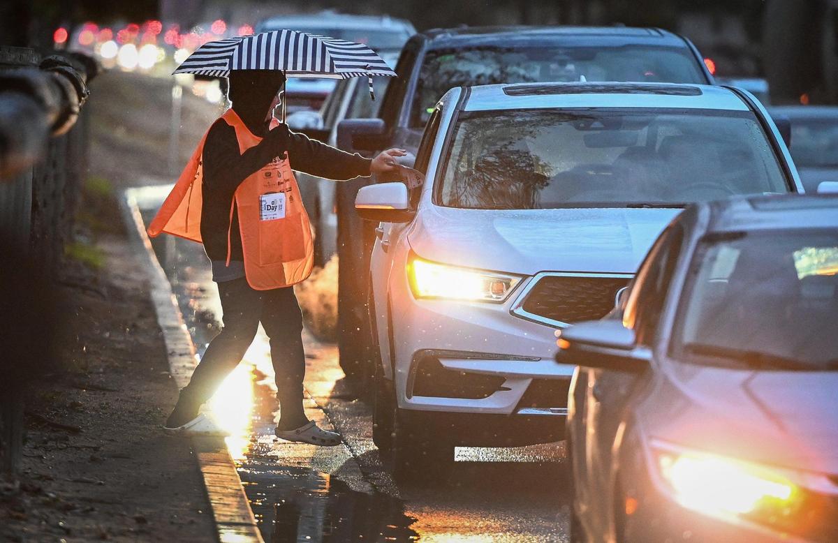Ethan Vankatesen, 14, sells a Kids Day newspaper at the corner of Friant and Audubon in Fresno on a rainy Tuesday, March 12, 2024.