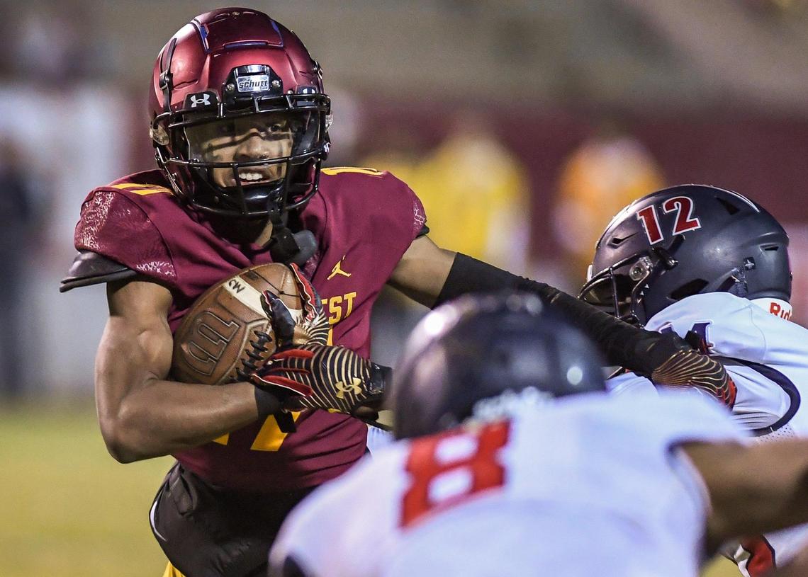 Clovis West’s Jonavon Darrington, left, looks for an opening around the Memorial defense while taking the ball to the outside during their Central Section semifinal playoff game at Lamonica Stadium in Clovis on Friday, Nov. 18, 2022.
