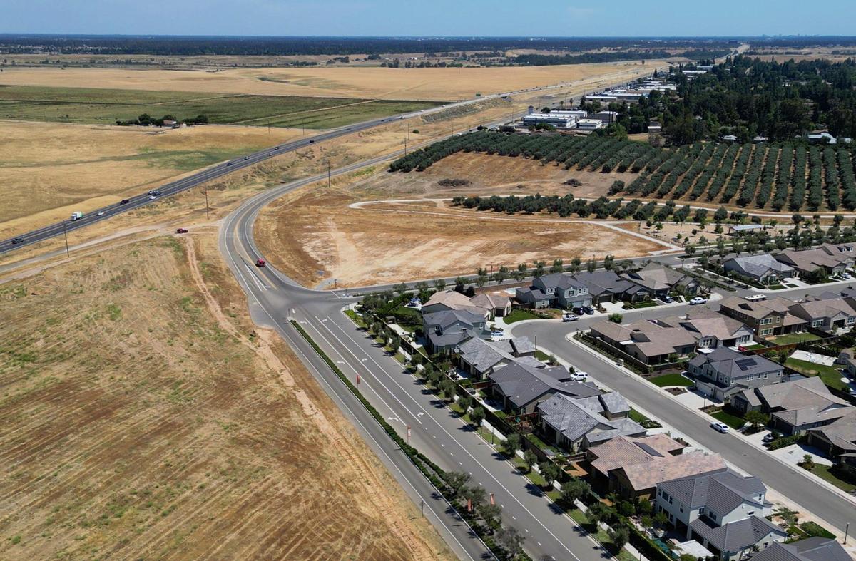 An area where Riley’s Brewery will be constructed along with a farmers market can be seen in the center, State Route 41 is seen to the left and Riverstone houses to the right with the city of Fresno in the distance Wednesday, June 14, 2023 near Madera Ranchos.