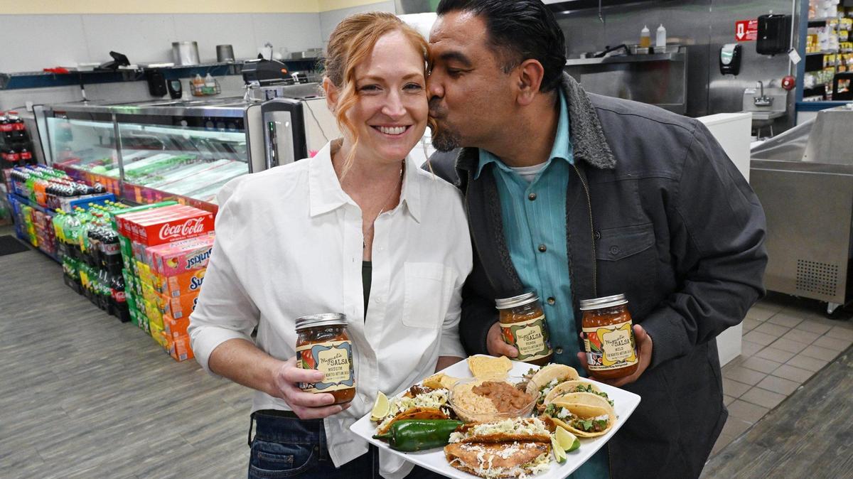 Miguel besa a su esposa Lisa Segura en la primera taquería de la pareja, donde ofrecen comida inspirada en Jalisco y la nueva colección de salsas de la pareja.