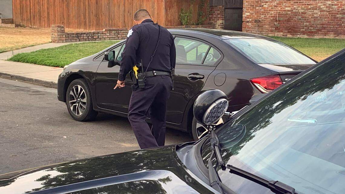 A Fresno police officer checks a car hit by gunfire early Monday near North Second Street and Mayfair Drive. No one was reported to have been injured.