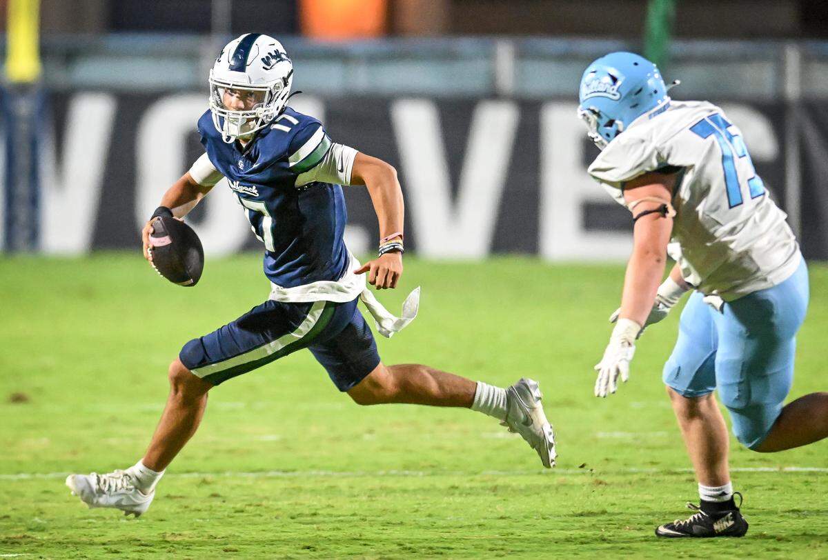 Clovis East quarterback Jamie Spurgeon scrambles away from Bullard’s Cade Branch during their game at Lamonica Stadium on Friday, Aug. 22, 2025.