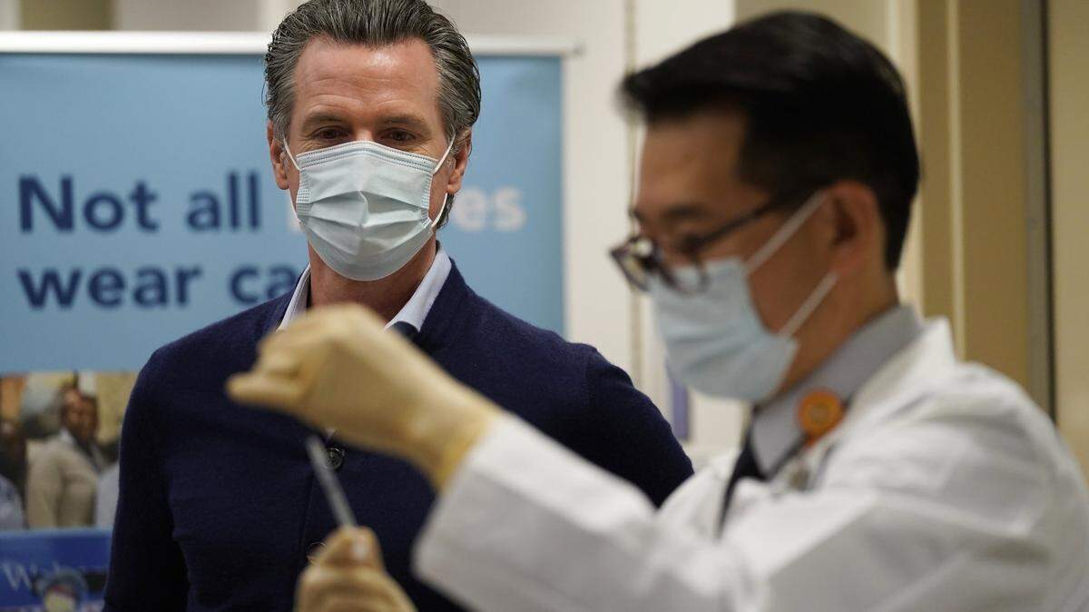 California Gov. Gavin Newsom watches as the Pfizer-BioNTech COVID-19 vaccine is prepared by Director of Inpatient Pharmacy David Cheng at Kaiser Permanente Los Angeles Medical Center in Los Angeles, Monday, Dec. 14, 2020. (AP Photo/Jae C. Hong)