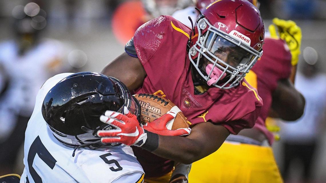 Clovis West’s Marshel Sanders, right, works for a few yards while being brought down by Edision’s Nathan Benjamin in their non league game at Veterans Memorial Stadium in Clovis on Friday, Sept. 3, 2021.