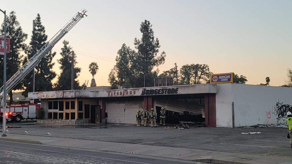 Fire crews work to clean up the scene after a vacant tire shop caught fire along Kings Canyon Road in southeast Fresno on Monday, Sept. 27, 2021.