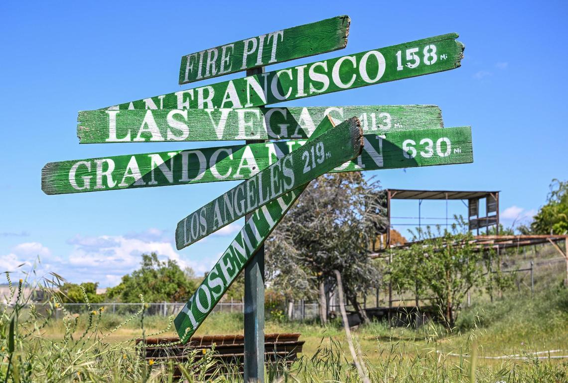 Signs point to various places in the outdoor backyard space at Yosemite Hemp Co. in Friant on Wednesday, April 4, 2025. The backyard space is used for various public and private events at the CBD shop.