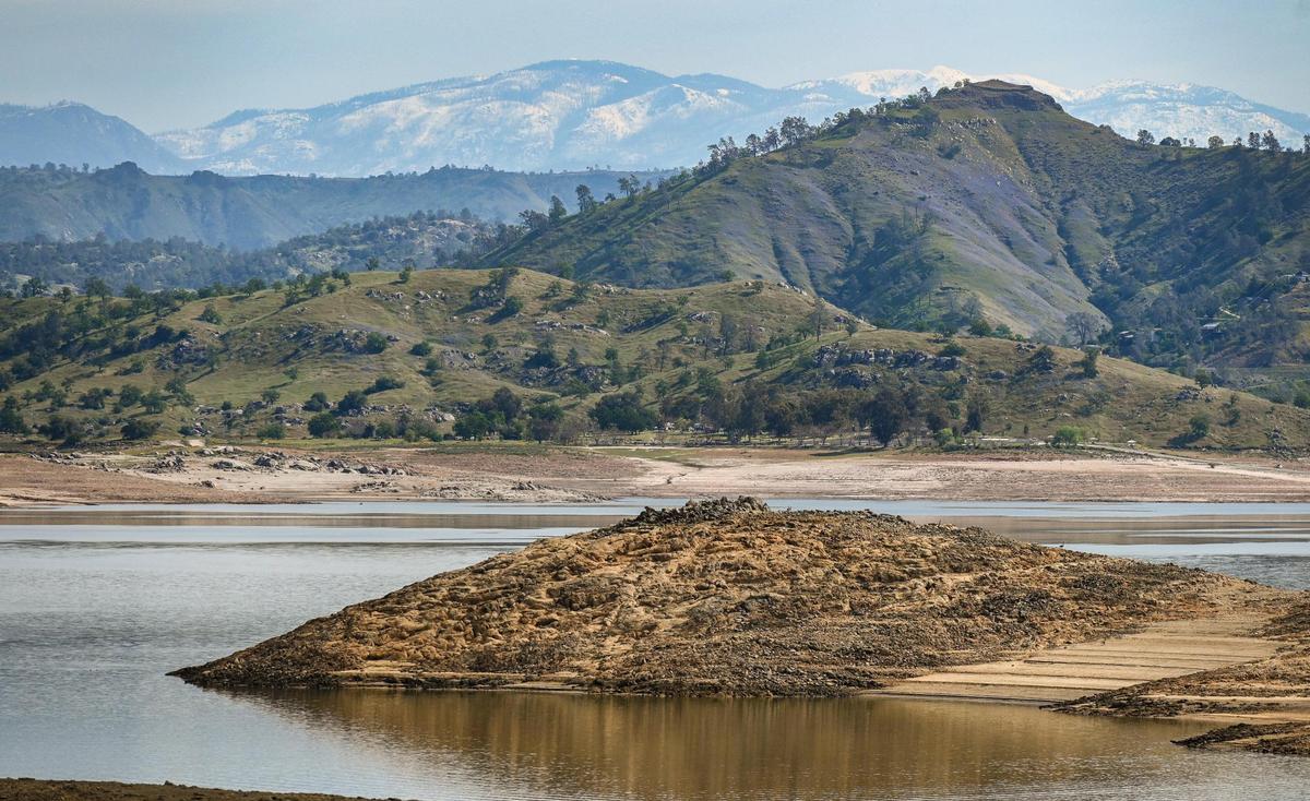Snow covers the Sierra Nevada mountains in the background as water runoff begins to fill Millerton Lake on Tuesday, April 11, 2023. Officials are expecting the massive snowpack will soon melt causing flooding issues downstream.