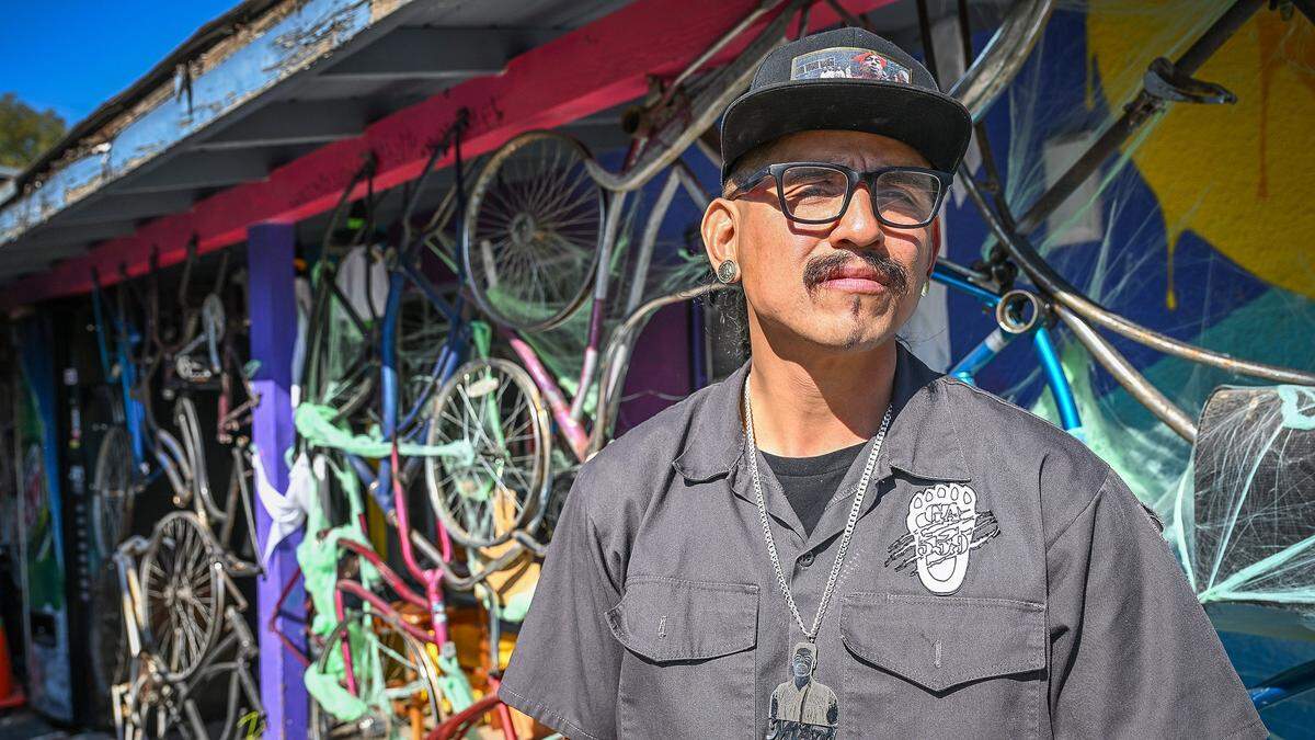 Luis Rodriguez stands outside his Fresno bike shop, Grizzalley Bike Shope, on the southern edge of the Tower District.
