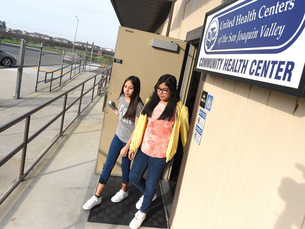 12-year-old twins Hailey, left, and Ashley Resendez, leave after checkups at United Health Center community clinic next to their school in Parlier, January 30, 2020.
