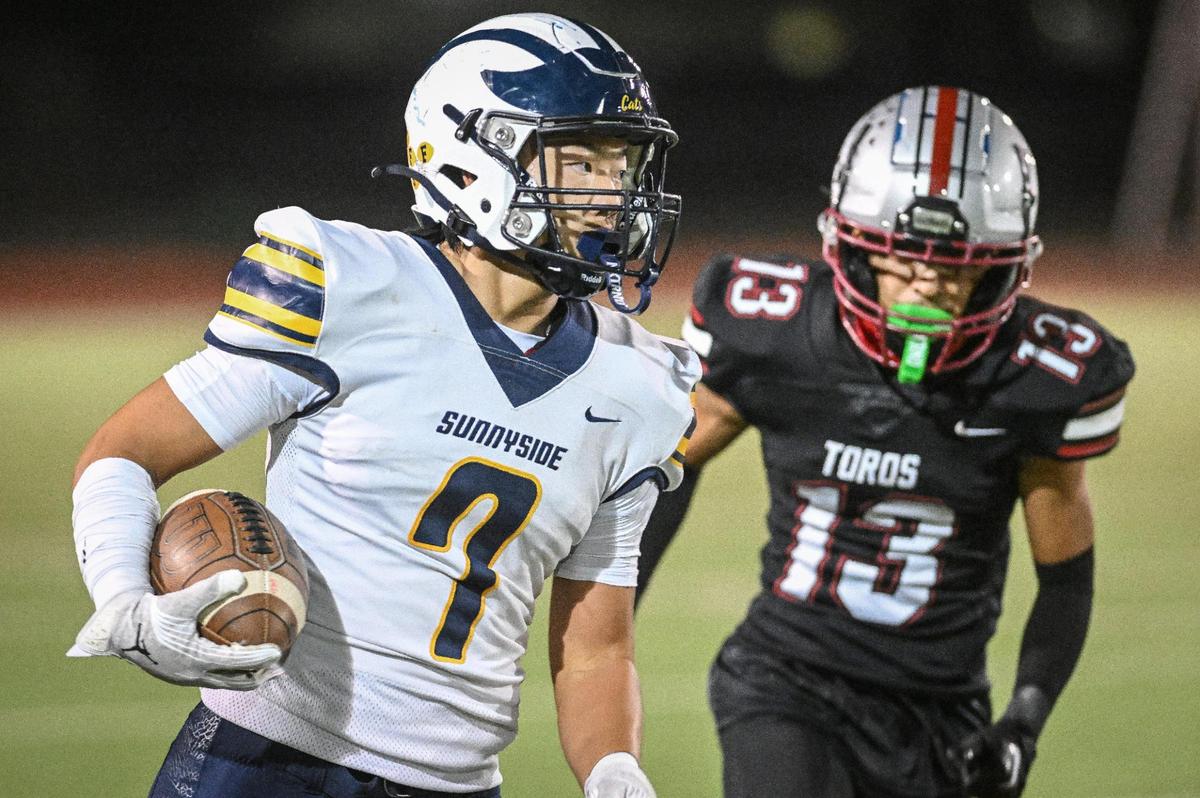Sunnyside’s Vian Vang, left, takes the ball down the sideline while chased by Torres’ Demetrio Nila in the first half of their game at Madera South High School football stadium on Friday, Oct. 13, 2023.