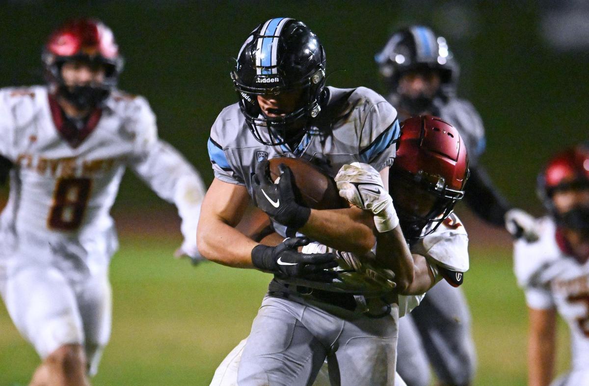 Clovis West’s Jordan Pierro, background, tackles Clovis North’s Jackson Cinfel on a run in a Central Section Division I quarterfinal game Thursday, Nov. 9, 2023 in Clovis.