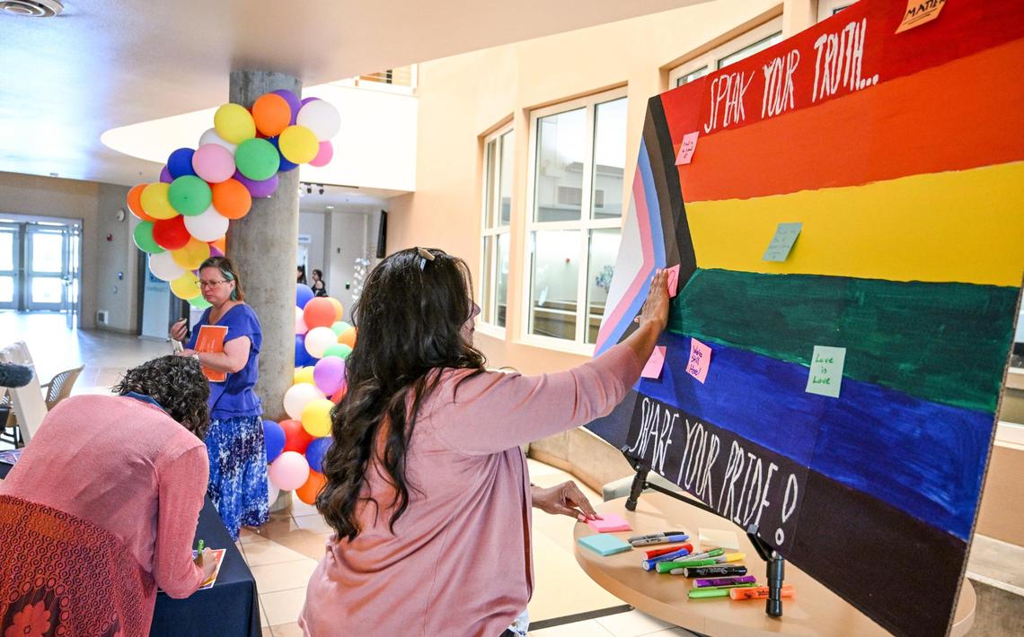 Title IX coordinator Renee Garcia posts a message on a Pride flag poster in the Academic Center at Clovis Community College in Clovis following a ceremony with students and staff to recognize June as Pride Month at the campus on Thursday, June 1, 2023.