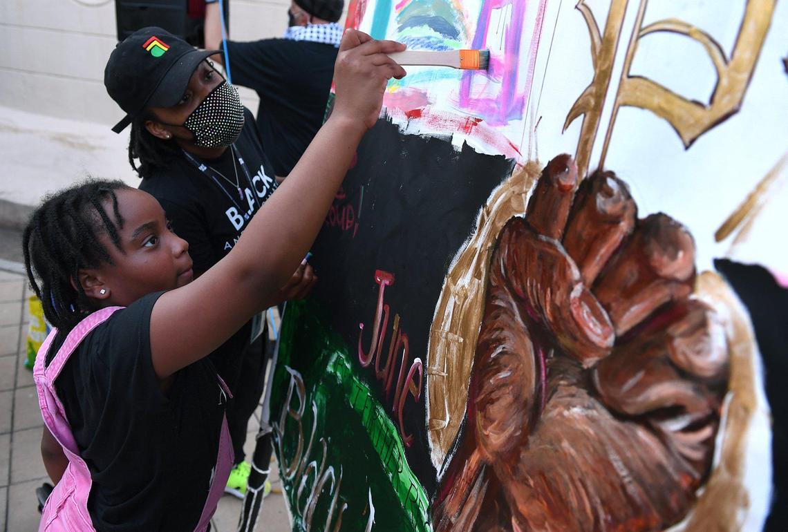 Darriell Austin, 9, with Brittnie Wilson watching, adds her art to Creative Fresno’s mobile mural at the Black Lives Matter Day: Black Joy event at Eaton Plaza on Friday evening, June 18, 2021. The event drew around 40 people and helped kick off Juneteenth celebrations in Fresno.