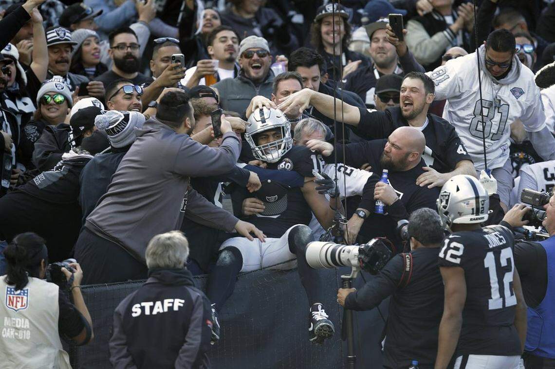 Oakland Raiders wide receiver Tyrell Williams is mobbed by fans after scoring a touchdown during the first half of an NFL football game against the Jacksonville Jaguars in Oakland, Calif., Sunday, Dec. 15, 2019.