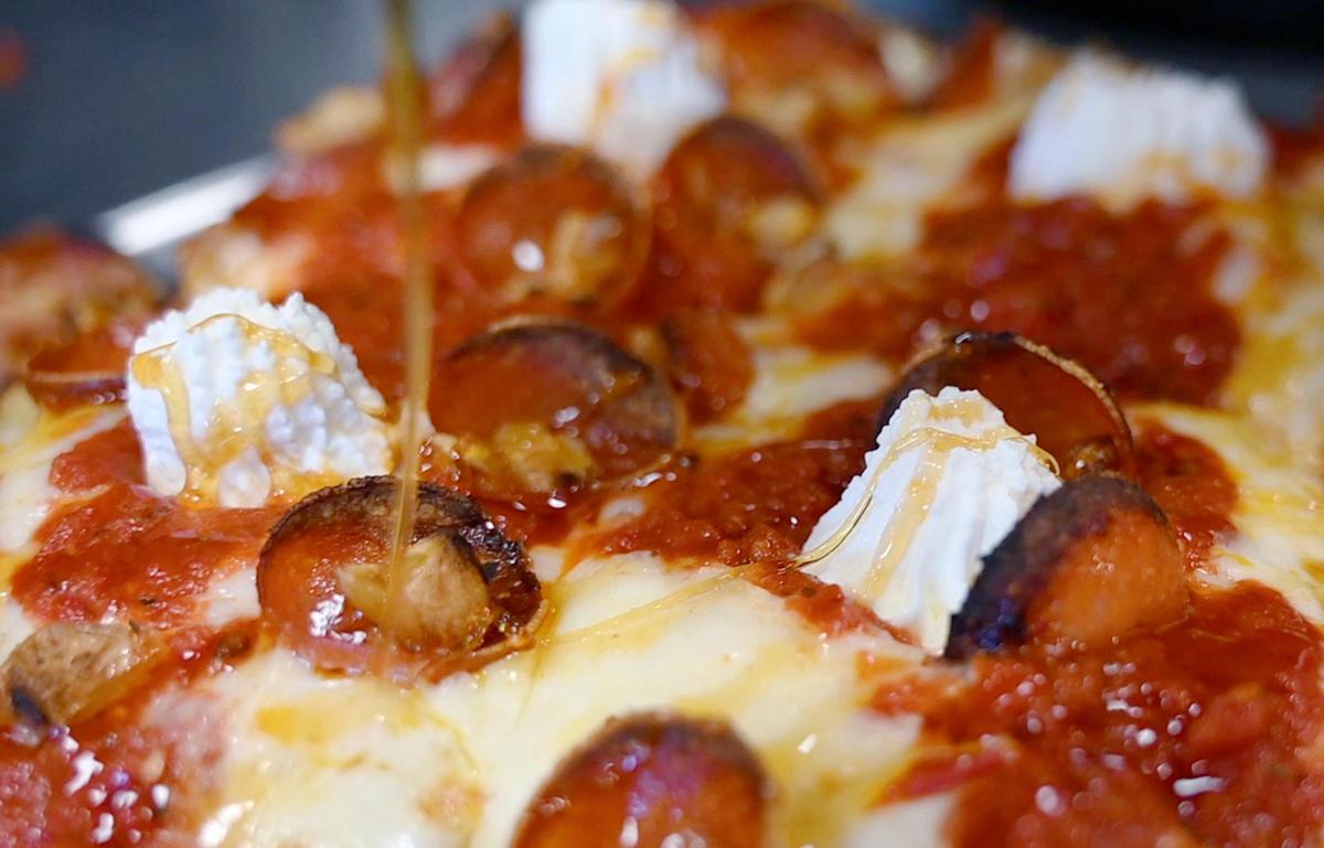 Hot honey is drizzled over the Pinnacles PBR Detroit-style pizza at the newly opened 99 Craft Pizza Wednesday, Aug. 3, 2022 in Fresno.
