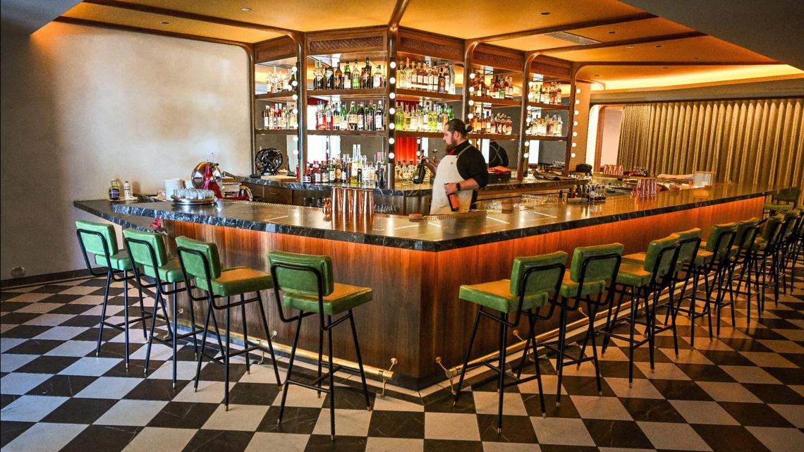 Bar director Ryan Metcalf stocks the shelves at The Red Room while getting ready to open the new bar inside Pardini’s catering venue on West Shaw Avenue in Fresno.