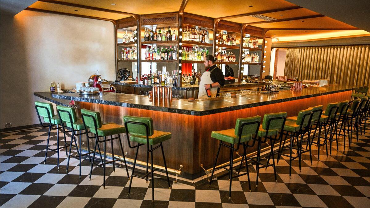 Bar director Ryan Metcalf stocks the shelves at The Red Room while getting ready to open the new bar inside Pardini’s catering venue on West Shaw Avenue in Fresno.