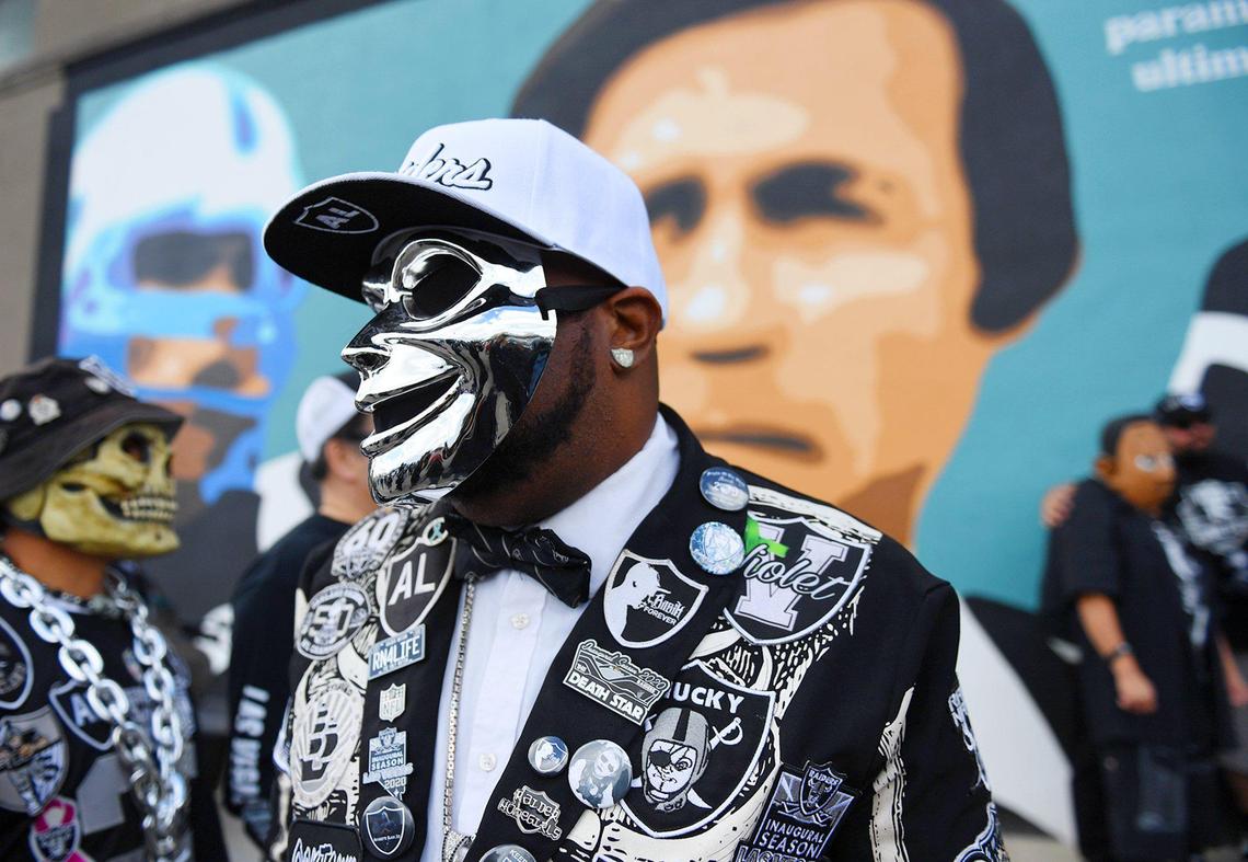 Kevin Guilford, AKA Mob Boss, center, looks around at the crowd of Raiders fans gathered at the mural honoring Hall of Fame coach Tom Flores in downtown Sanger on Saturday, Feb. 20, 2021.