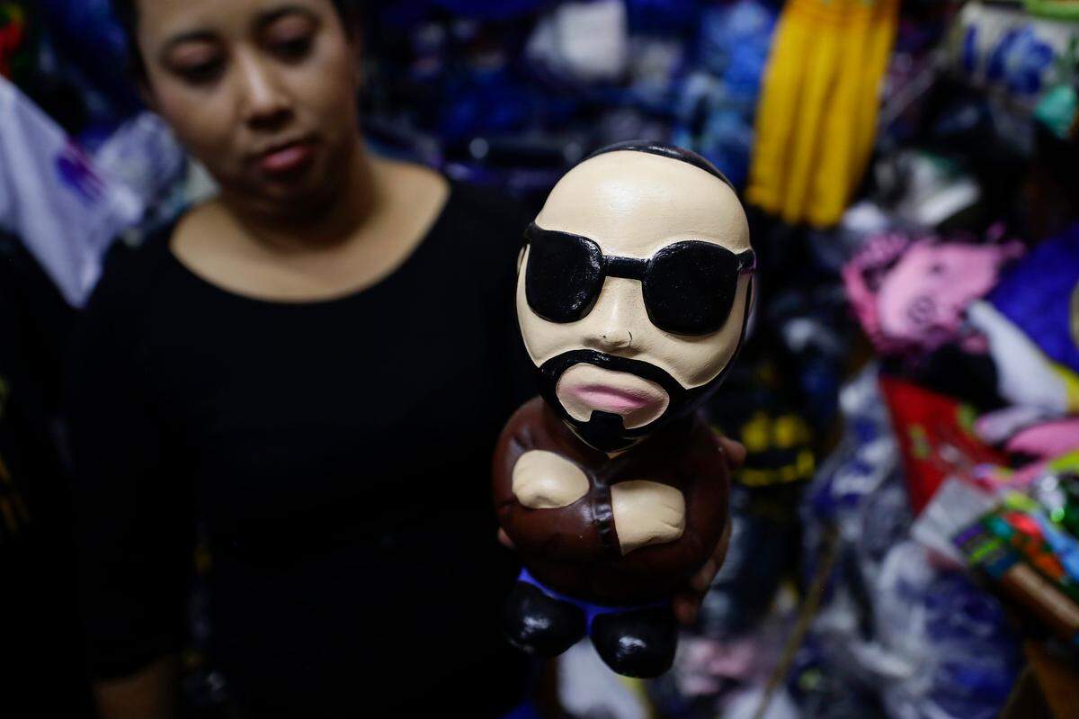 Una mujer muestra una alcancía alusiva al presidente Nayib Bukele en el centro de San Salvador, El Salvador. La seguridad y los derechos humanos se colocan como los polos opuestos de la gestión de Nayib Bukele como presidente de El Salvador, quien goza de una altísima popularidad, pero también es criticado por autoritarismo, concentración de poder y atropellos en su guerra contra las pandillas.
