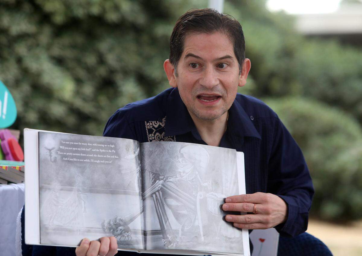 El presidente de Fresno State, Saúl Jiménez-Sandoval, lee el libro 'La araña y la mosca' a niños durante la séptima Feria Educativa en Fresno State, el 22 de octubre de 2022.