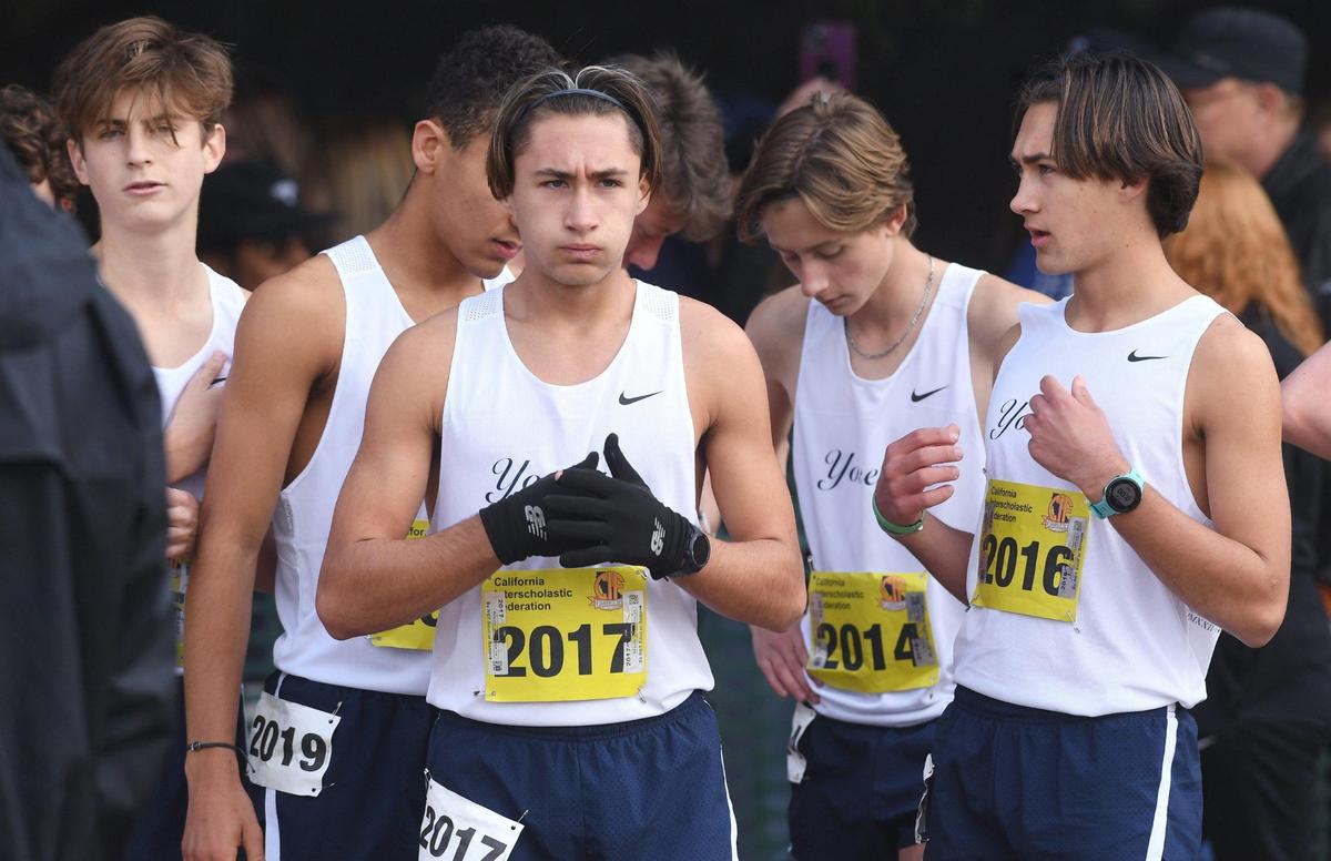 Yosemite’s Jack Olney, #2017, with his twin brother Ben Olney, #2016, stand with the team at the Boys D-V starting line at the CIF state cross country championship meet Saturday, Nov. 26, 2022 in Fresno.