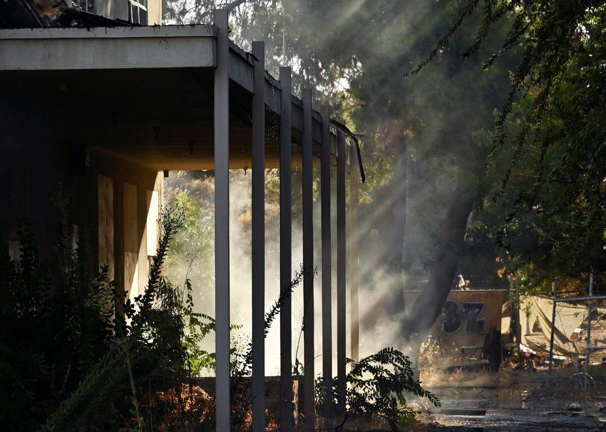 Shafts of light cut through the smoke as the former Fresno County Coroner’s building burns Tuesday morning, Sept. 24, 2024 in Fresno.