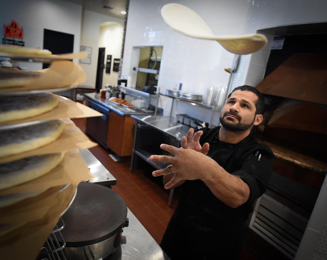 Blast & Brew kitchen manager Joseph Ramirez tosses pizza dough at the new location near Palm and Herndon avenues.