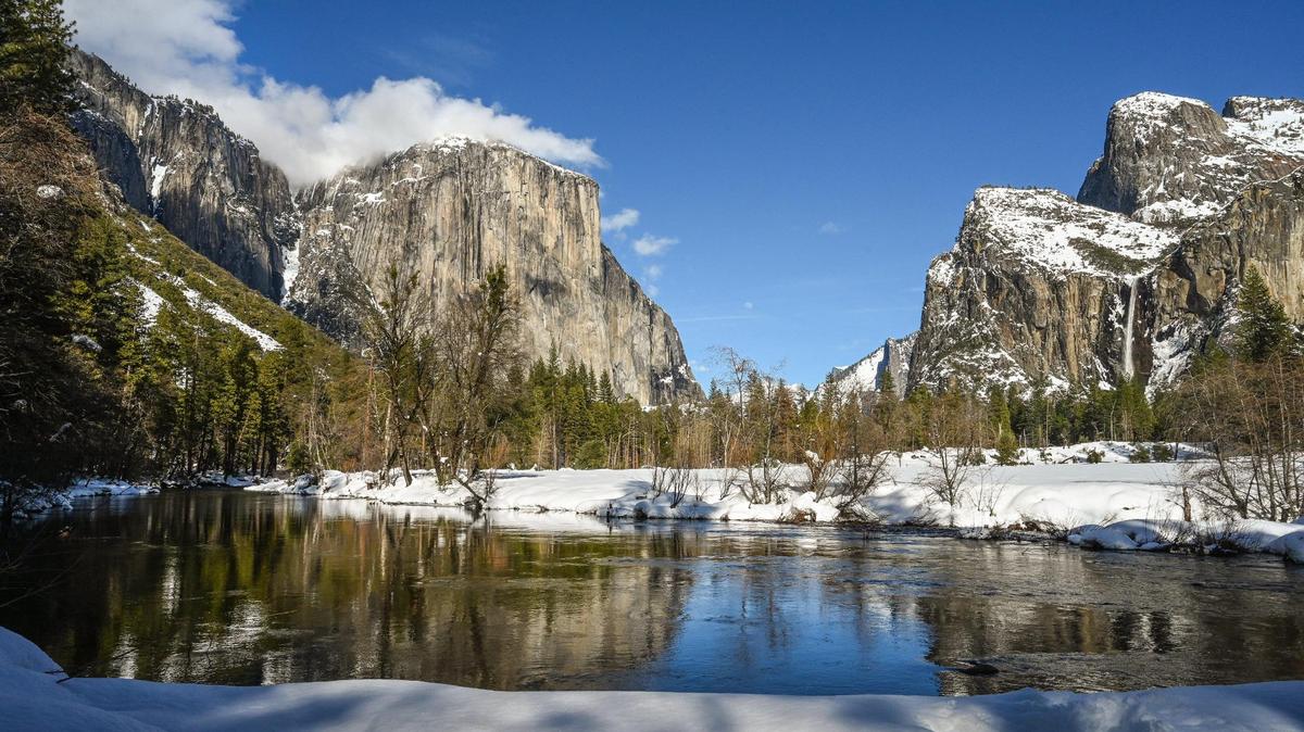 Clouds graze the top of El Capitan, left, as Bridalveil Fall, right, flows down into Yosemite Valley and the Merced River in March. A key road to Yosemite for visitors coming from Sacramento and other points north is expected to be shut down through the summer, park officials said.