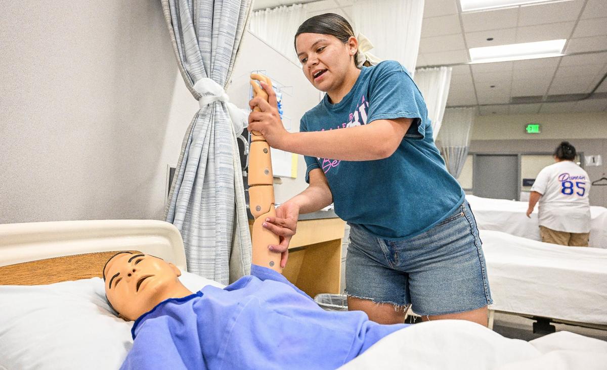 Duncan Polytechnic High School senior Taylor Cruz practices CNA program skills in the hospital lab at the school on Wednesday, May 22, 2024.