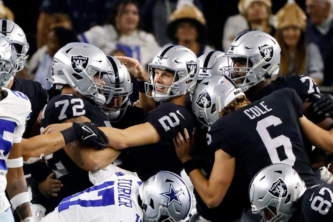 Las Vegas Raiders kicker Daniel Carlson is congratulated by Jermaine Eluemunor, AJ Cole and others after Carlson kicked a game-winning field goal in overtime of an NFL game against the Dallas Cowboys in Arlington, Texas, Thursday, Nov. 25, 2021.