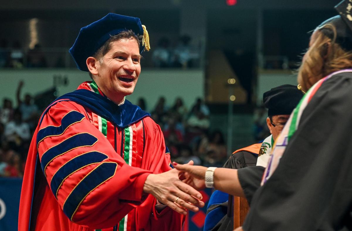 Fresno State President Saúl Jiménez-Sandoval shakes hands with graduates during the 47th annual Fresno State Chicano/Latino Commencement Celebration at the Save Mart Center on Saturday, May 20, 2023.