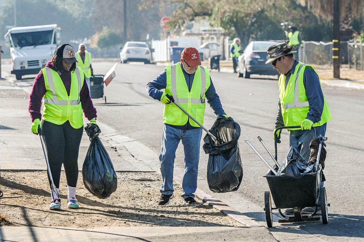 Volunteers pick up trash along Harrison Avenue in north Fresno during a Beautify Fresno “neighborhood blitz” cleanup event on Saturday, Dec. 9, 2023.