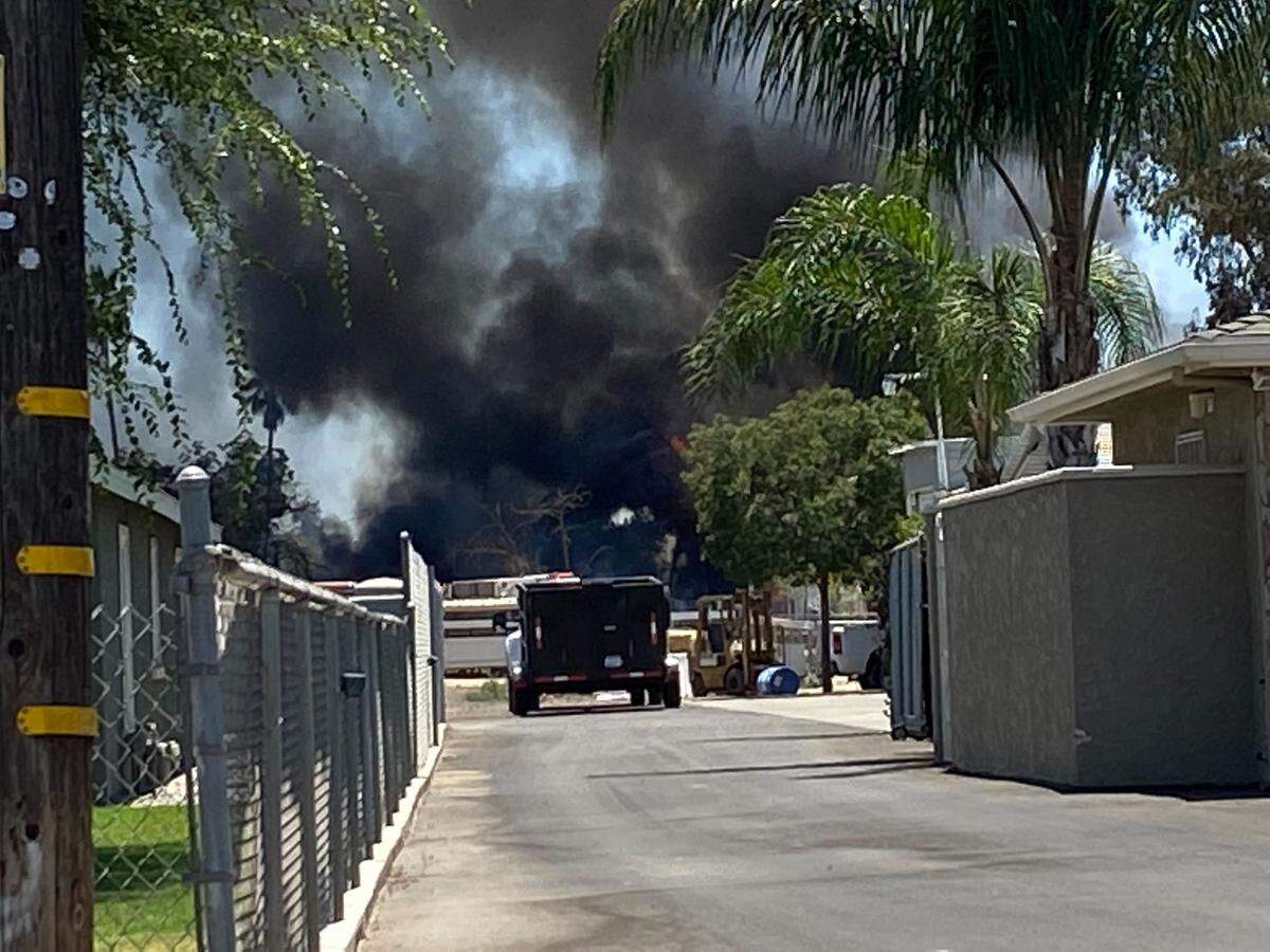 Black smoke wafts into the air near Belmont and Brawley avenues in Fresno, California, on Monday, July 11, 2022.