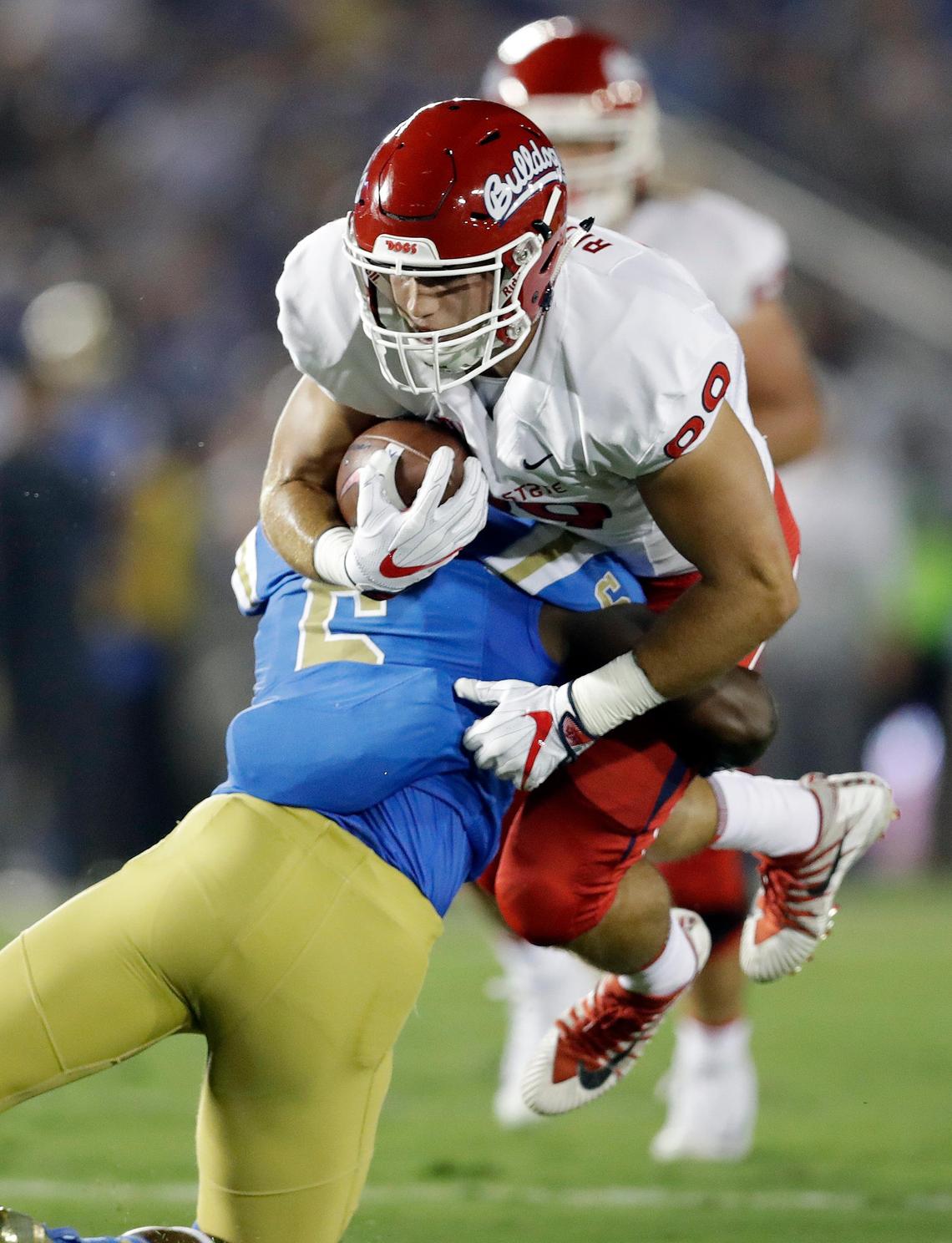 Fresno State tight end Kyle Riddering, top, is tackled by UCLA linebacker Josh Woods after a reception during the first half of an NCAA college football game Saturday, Sept. 15, 2018, in Pasadena. Fresno State led 16-7 at halftime.