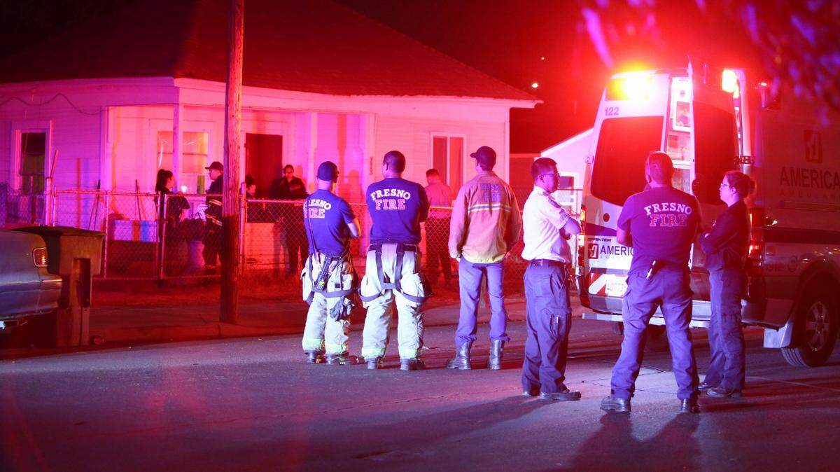 Firefighters at the scene where a body was found in a shed Monday night at North Fourth Street and East Thomas Avenue.