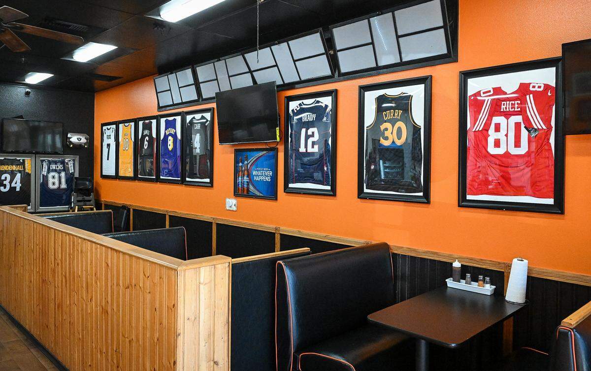 Pro sports jerseys adorn the walls at Weekend Dreams Burgers & Grill in west Fresno where the owners are huge sports fans.