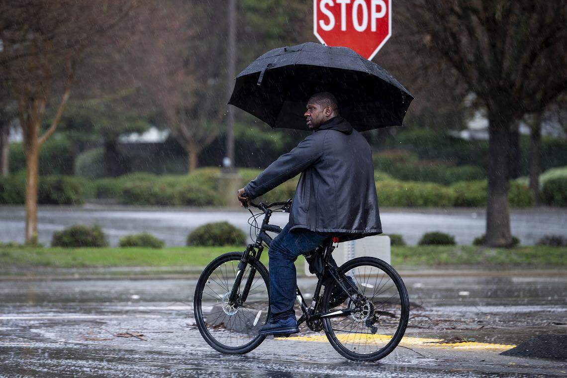A bicyclist crosses M Street at Buena Vista Drive during a short rain and hail storm in Merced, Calif., on Monday, Jan. 16, 2023.