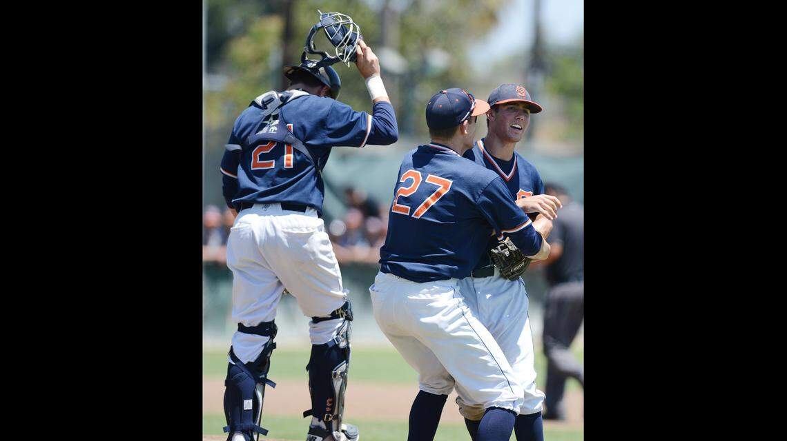 College of the Sequoias’ Dylan Lee, center, hugs pitcher Blake Edmonson who closed out their Junior College baseball state finals game against Oxnard at Euless Park Sunday, May 25, 2014.