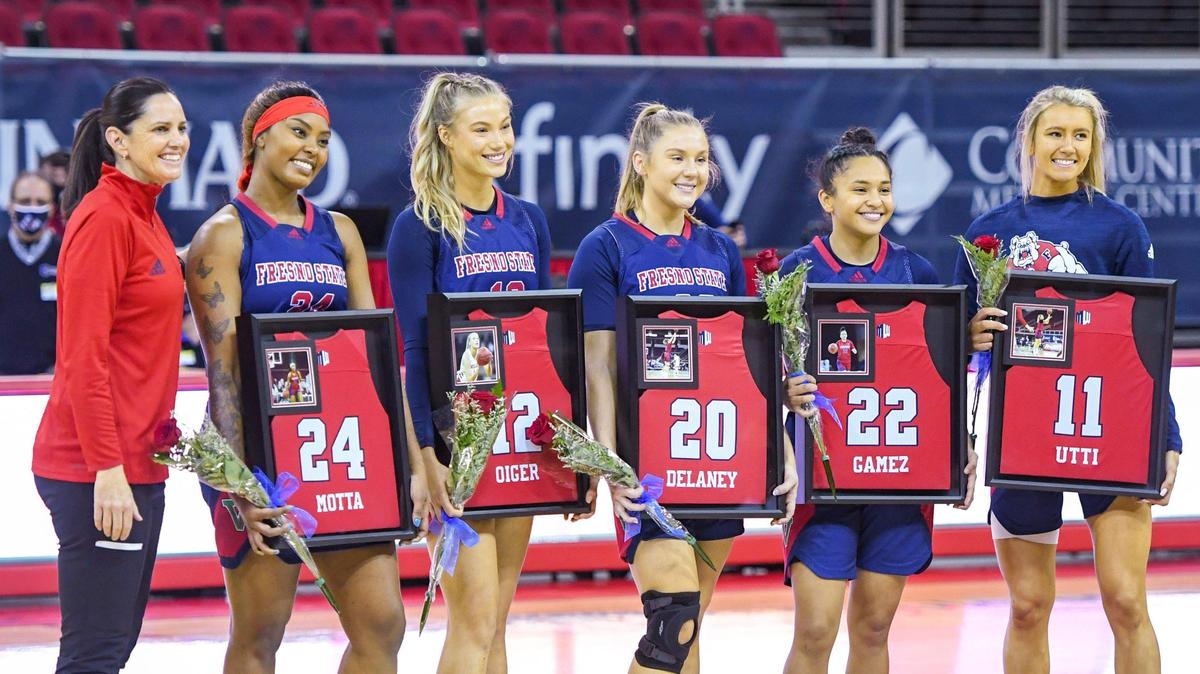 Fresno State’s graduating seniors, from left, Wytalla Motta, Gonna Ogier, Bree Delaney, Aly Games, and Maddi Utti pose for photos with framed jerseys with coach Jamie White before the start of their game against UNLV at the Save Mart Center on Saturday, Feb. 27, 2021.