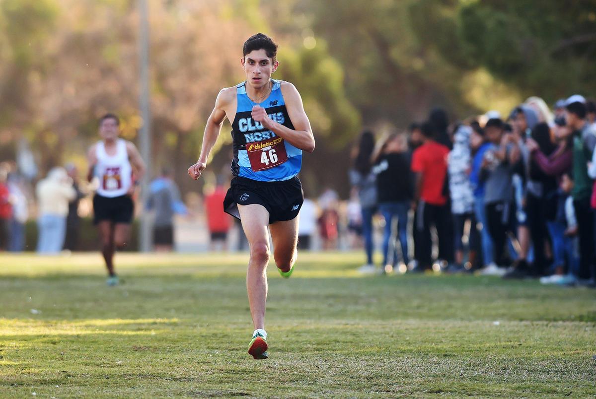 Clovis North’s Isaiah Galindo, right, leads second-place finisher Damian Gavilan from Paso Robles, left background, as Galindo wins the Central Section Division I cross country championships held Thursday, Nov. 21, 2019 at Woodward Park in Fresno.