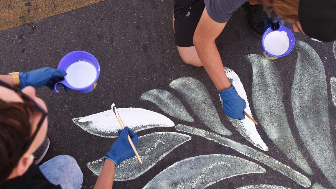 Volunteers paint the intersection at N. Van Ness Blvd and Weldon Ave. Saturday, July 6, 2019 in Fresno.