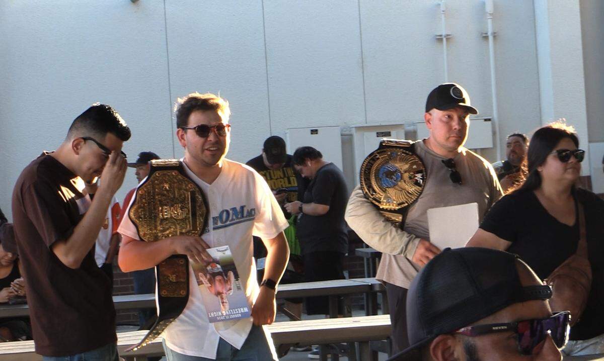 Fans wait their turn to have their merchandise signed by Kurt Angle.