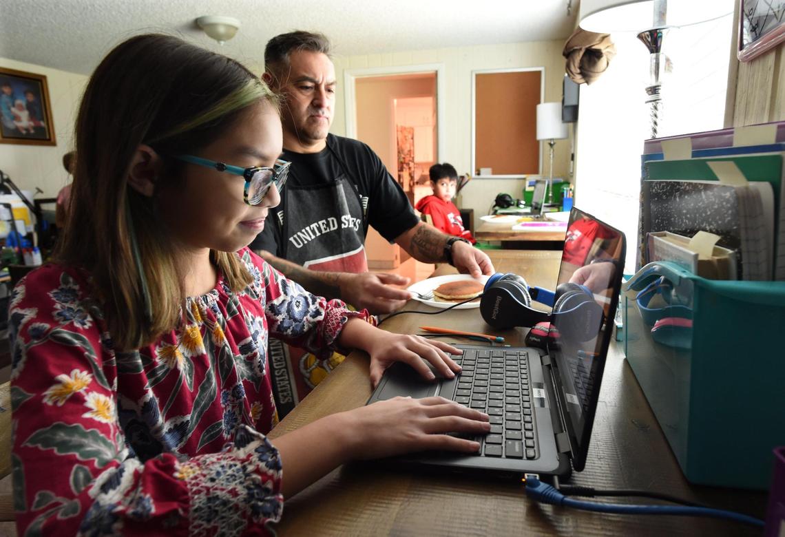 Esteban Pacheco brings his daughter, Thomas Elementary 5th grader Audrey Pacheco, pancake breakfast as she does her school work online, Thursday Oct. 29, 2020.