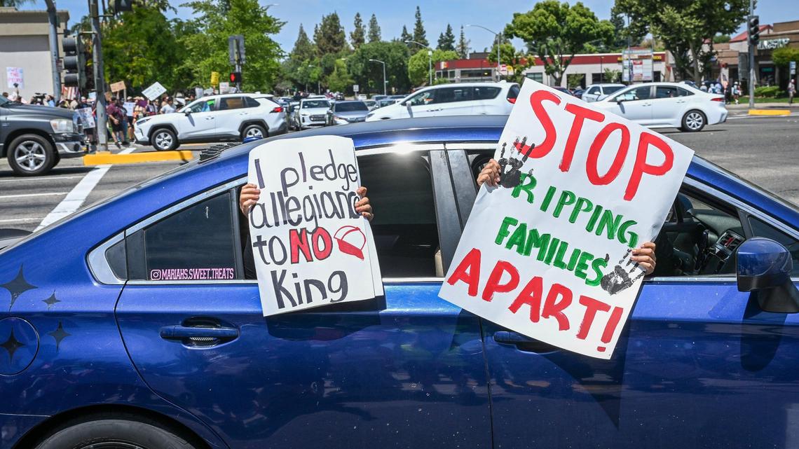 Protestors wave signs from a car as it passes protestors on Blackstone Avenue at Nees near River Park shopping center during a no kings protest against President Donald Trump’s policies in Fresno on Saturday, June 14, 2025.
