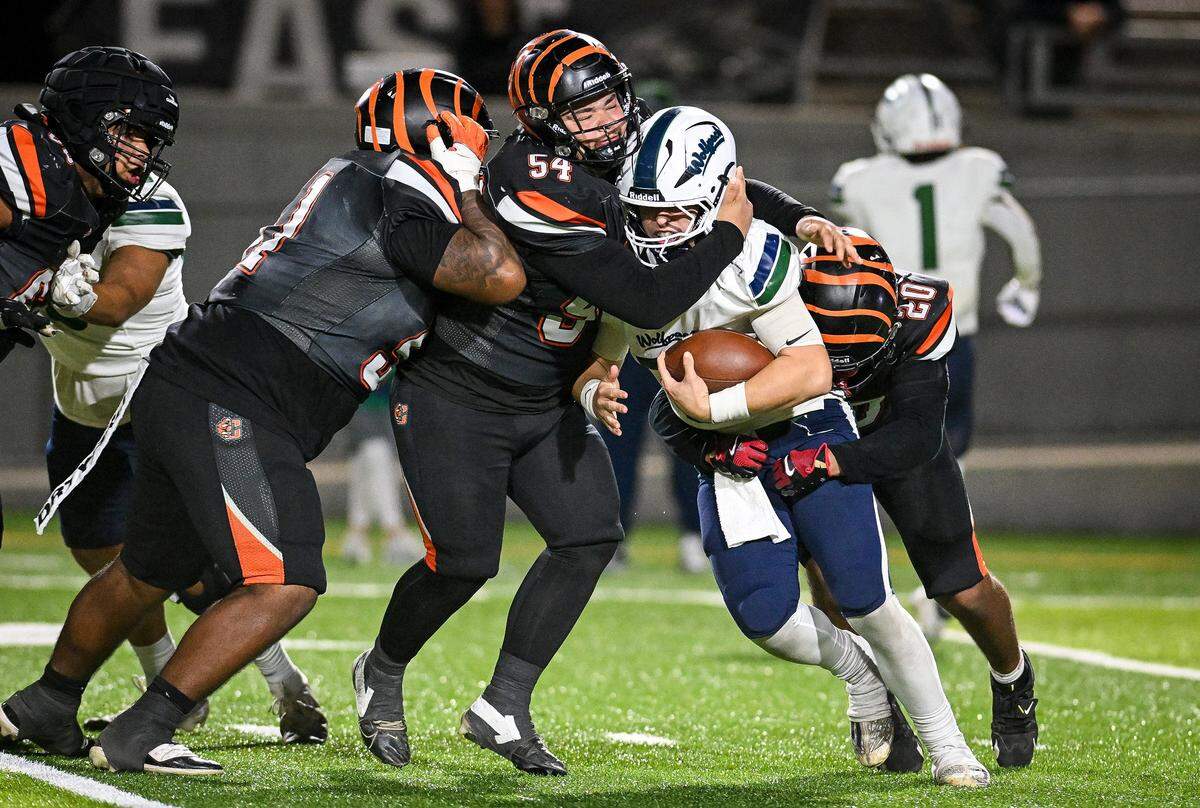 Clovis East's quarterback Tristan Kircher gets hit behind the line by Central East's John Kyle for a sack during their playoff game at Deran Koligian Stadium in Fresno on Friday, Nov. 7, 2025.