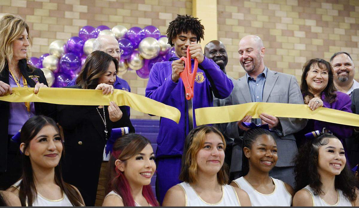 Fresno High student-athlete Kai Alfa, top center, cuts the ribbon with FUSD superintendent Kisty Her to the left and board trustee Andy Levine to his right, during a ceremony for a new auxiliary gym at Fresno High School Thursday, Feb. 5, 2026 in Fresno.
