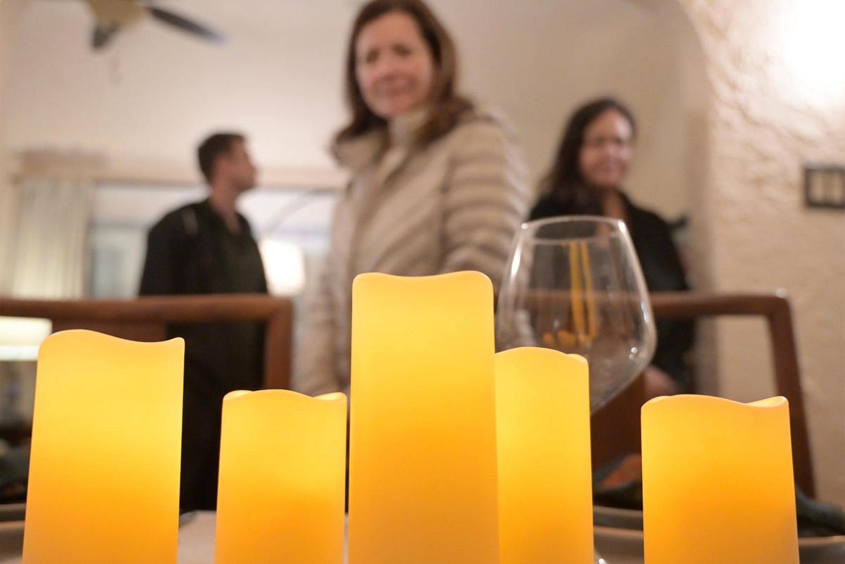 Guests pass a dining table with candles during the 2024 Fresno High Neighborhood Holiday Home Tour Monday evening, Dec. 2, 2024.