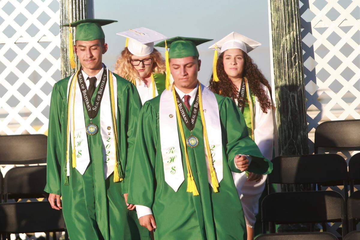 Riverdale High School class salutatorians Giovanni Roa, front left, Leona Phillips, back left, and Iván Ibarra, front right, with valedictorian Isabela González (back right) as they enter the stage during the graduation ceremony Friday night (June 10) at Cowboys Stadium Jack King Field.